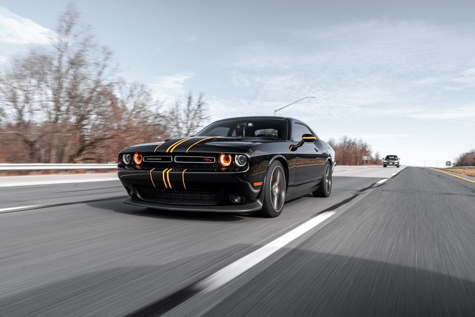 High-performance black car driving fast on a highway with dynamic motion blur.