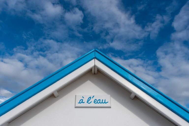 A minimalist view of a beach hut roof with blue and white colors set against a vibrant blue sky.
