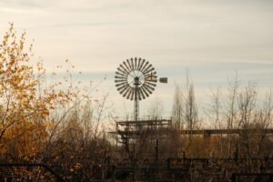 A solitary windmill stands tall amidst autumn foliage in Duisburg, Germany, capturing a serene fall atmosphere.