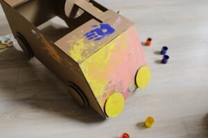 Brightly painted cardboard box car craft, ideal for kids' playtime and educational activities.