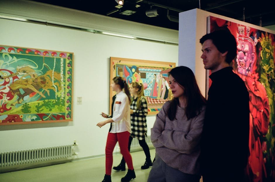 Visitors engaged with vibrant art pieces in a St. Petersburg gallery, showcasing modern creativity.