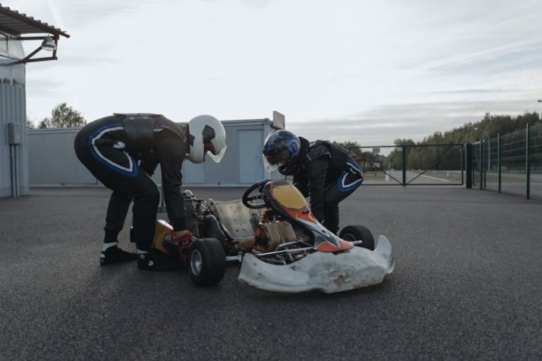 Two racers inspect their go-kart on a racetrack for an upcoming race event, enhancing sportsmanship and precision.