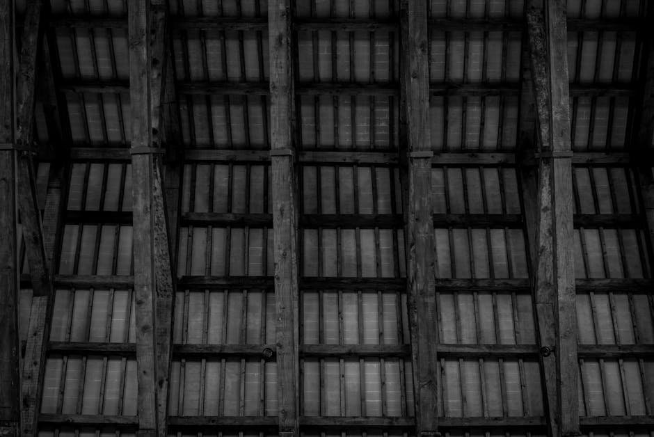 High contrast image of a wooden ceiling with rustic trusses in monochrome.