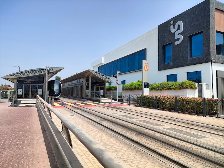 A sleek tram station with rails on a sunny day, featuring contemporary architecture.